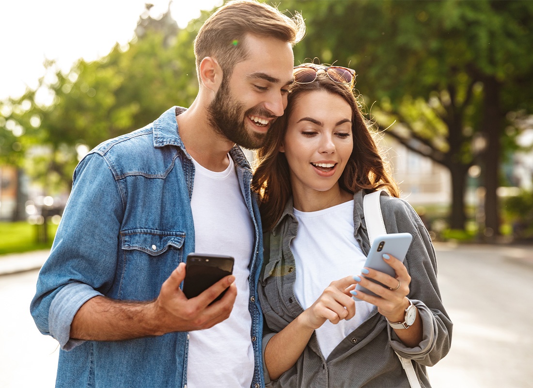 Read Our Reviews - Young Couple Looking at Their Phones While Standing Outside